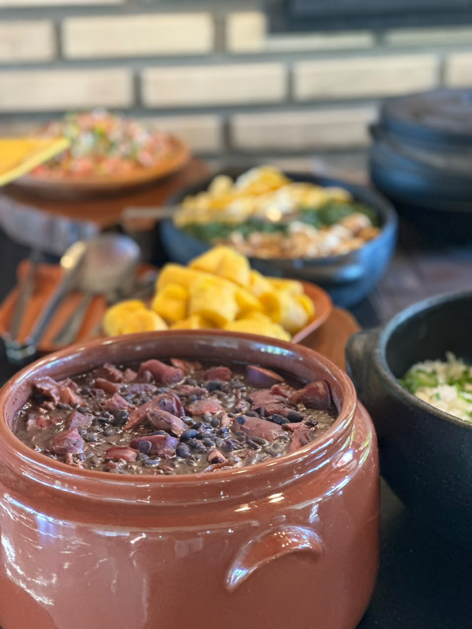 Panela de feijoada DuPorco completa, com acompanhamentos à mesa